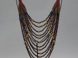 beaded necklace on a stand on a white background
