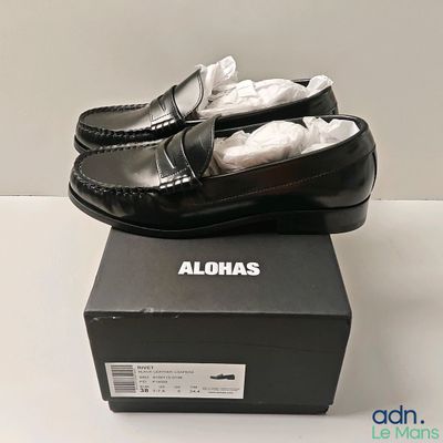 une boîte sur laquelle est posée une paire de chaussures noires