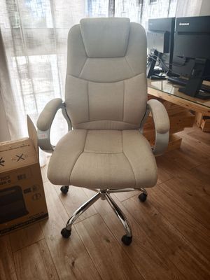 une chaise de bureau blanche placée devant une fenêtre