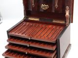 a small wooden chest with drawers on top of it