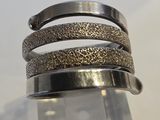 un gros plan sur un bracelet en argent surmonté d'un anneau métallique