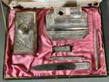 a silver box with a knife, mirror, and other items in it