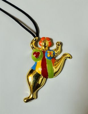 gold plated necklace with a multicolored design on a black cord