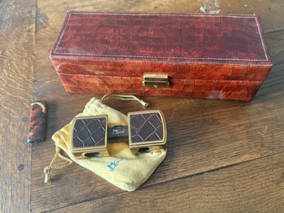 a red case and a brown case sitting on a wooden floor