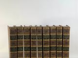six vieux livres empilés les uns sur les autres sur une surface blanche