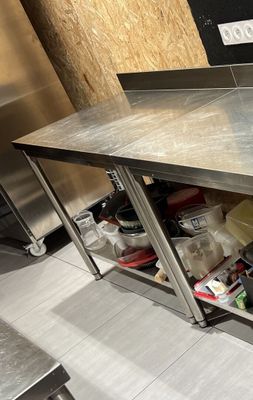 une grande table en inox sur laquelle sont disposés tout un tas de plats