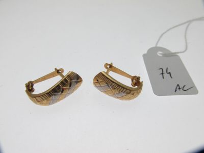 deux paires de boucles d'oreilles en or avec une étiquette de prix posée sur un fond blanc