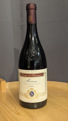 a bottle of wine sitting on a table next to a bottle of wine