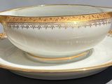a white and gold cup and saucer on a saucer