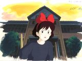 an image of a woman with a red bow standing in front of a house