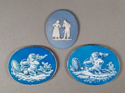 trois assiettes bleues et blanches ornées de personnages, posées sur une table