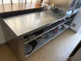 a large stainless steel counter with pots and pans on it