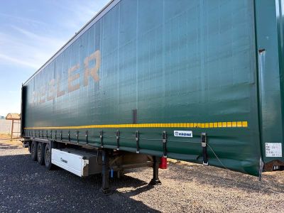 une semi-remorque verte garée sur le bord de la route
