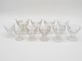 Plusieurs verres à pied et tasses sont alignés sur une surface blanche