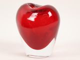 a glass vase with a red apple inside of it