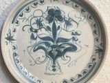 a blue and white plate with a flower design on it