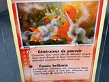 une carte Pokémon dans un étui en plastique posé sur une table