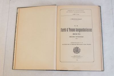 un livre ouvert posé sur une table blanche à côté d'une tasse de café