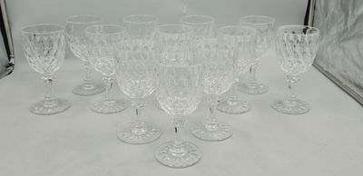 six clear wine glasses sitting on top of a table next to a mirror