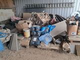 a pile of junk in a garage with a lot of boxes on the floor