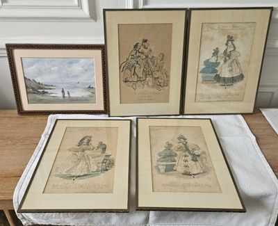 trois gravures encadrées représentant des femmes et des enfants posées sur une table