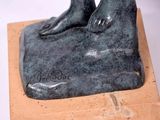 a statue of a person sitting on top of a rock