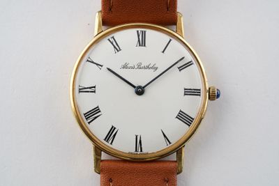 une image d'un gros plan d'une montre-bracelet avec des chiffres romains