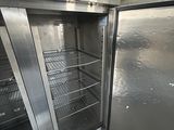 a silver refrigerator that is open in a room