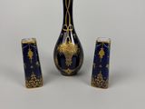trois vases bleus et dorés posés sur une table