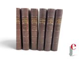 several books are lined up in a row on a white surface