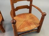 pair of wooden chairs with cane back and seat cushions