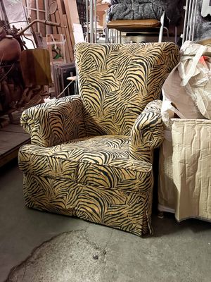 a zebra print chair and ottoman in a warehouse