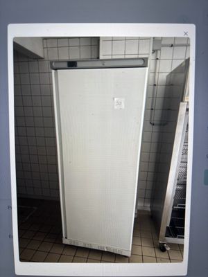 une photo d'un réfrigérateur blanc dans une salle de bains