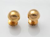 une paire de boucles d'oreilles plaquées or sur un fond blanc