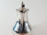 an image of a silver teapot with a lid on a white background