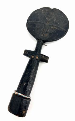 a black object with a wooden handle on a white surface