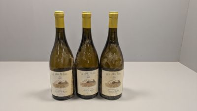 trois bouteilles de vin posées sur une table blanche