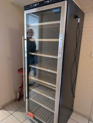 Quelqu'un prend une photo d'un refroidisseur à vin dans une pièce.
