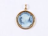 a close up of a pendant with a woman ' s face in a gold frame