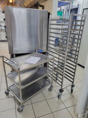un chariot métallique sur lequel sont posés plusieurs plateaux, dans une cuisine