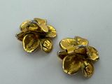 pair of gold tone flower earrings on a white surface