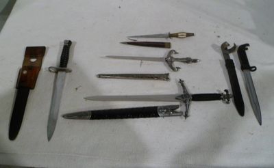 several different types of knives are displayed on a white cloth