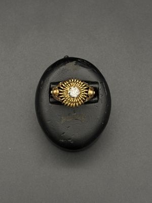 un gros plan d'un bouton noir orné d'un anneau doré