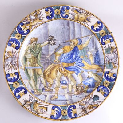 une assiette décorative ornée d'une peinture, accrochée au mur