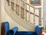 un canapé bleu placé devant un escalier