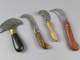 four different types of knives are lined up on a white surface