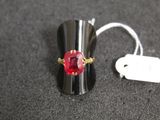 a ring with a red stone on it and a price tag