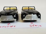 two toy cars sitting next to each other on a table
