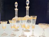 cinq verres à vin et une carafe posés sur une table