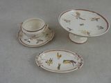trois assiettes et tasses posées sur une table, avec une tasse et une soucoupe